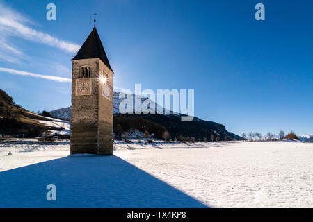 Italien, Vinschgau, versunkene Turm in gefrorenen Lago di Resia im Winter Stockfoto