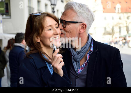 Reifes Paar zu Fuß in der Stadt, Frau rauchen elektronische Zigarette Stockfoto