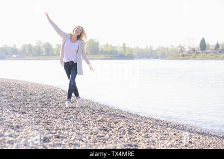 Sorglos reife Frau am Flußufer Stockfoto