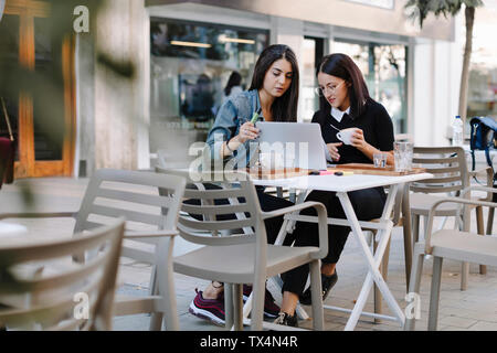 Zwei Freunde sitzen zusammen in einem Cafe mit Laptop Stockfoto