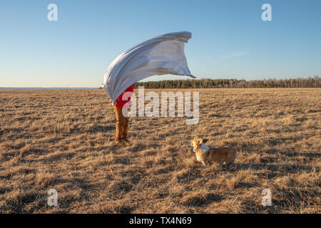 Hund und Junge mit Superheld Kostüm in Steppen Landschaft Stockfoto