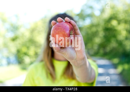 Porträt der jungen Frau mit Brille, mit einem Apfel Stockfoto