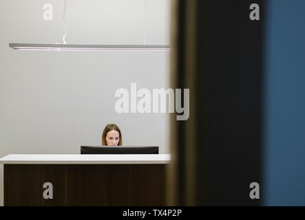 Junge Frau an der Rezeption in die Arbeit im Büro Stockfoto