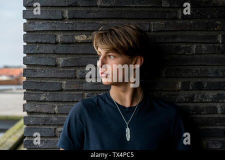 Portrait des jungen Mannes gegen eine Wand gelehnt Stockfoto