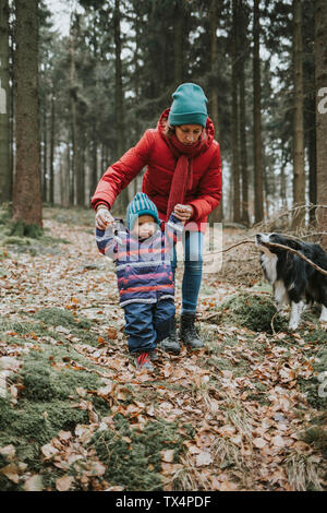 Mutter mit Tochter und Border Collie im herbstlichen Wald Stockfoto