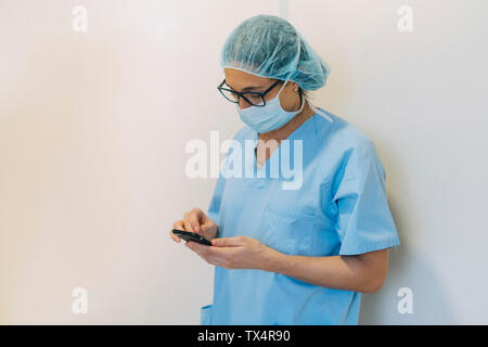 Ärztin mit im Krankenhaus, Smartphone, Vorbereitung für die Chirurgie Stockfoto