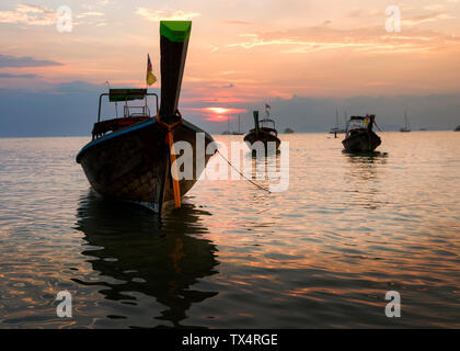 Thailand, Krabi, Railay Beach, Long-tail Boote auf dem Wasser schwimmend bei Sonnenuntergang Stockfoto