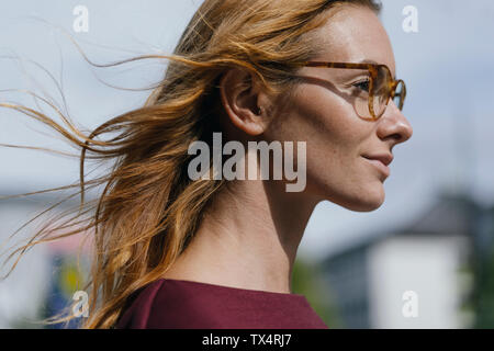 Profil von junge Frau mit Brille und windgepeitschten Haar Stockfoto