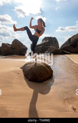 Seychellen, Mahe, Takamaka Beach, Frau, die auf einem Felsen Schattenboxen Stockfoto