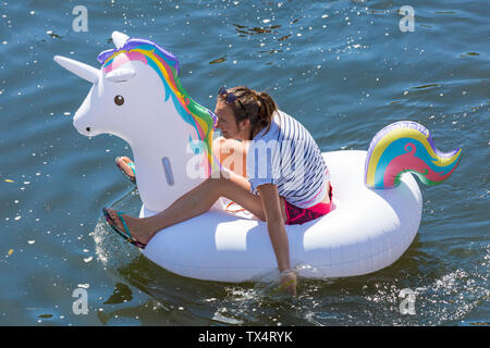 Frau Spaß auf aufblasbaren Einhorn aufblasbare auf Dorset Beiboot Tag an Iford gehen entlang des Flusses Stour zu Tuckton, Dorset UK im Juni Stockfoto