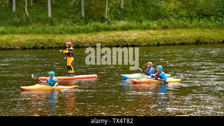 RIVER SPEY SCHOTTLAND PADDLE BOARD UND DREI KAJAKS RUBRIK FLUSSABWÄRTS AUF DEM FLUSS Stockfoto