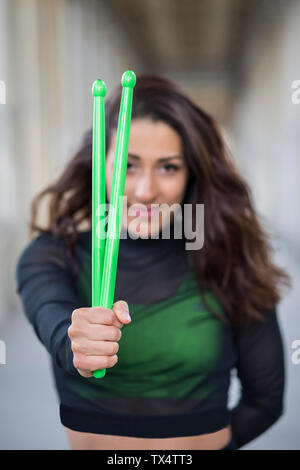 Portrait von lächelnden jungen Frau mit Pound übung Stöcke Stockfoto