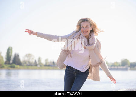 Sorglos reife Frau am Flußufer Stockfoto