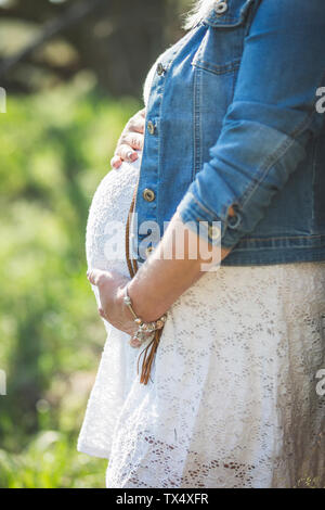 Schwangere Frau hielt Bauch, in der Nähe Stockfoto