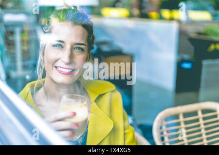 Portrait von lächelnden Frau hinter Fensterglas in einem Cafe Stockfoto