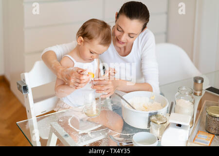 Mutter und Tochter einen Kuchen zusammen in der Küche zu Hause. Stockfoto