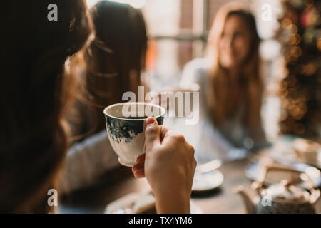 In der Nähe von Frau mit Freunden in einem Cafe holding Schale Stockfoto