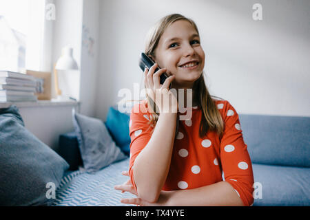 Glückliches Mädchen am Telefon zu Hause Stockfoto