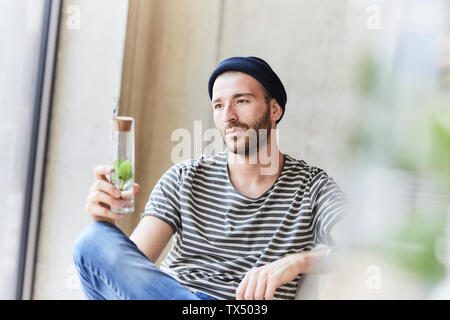 Nachdenklichen jungen Mann mit Anlage in einem jar Stockfoto