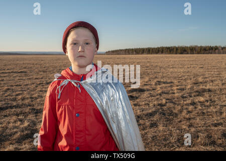 Portrait der Junge verkleidet als Superheld in Steppen Landschaft Stockfoto