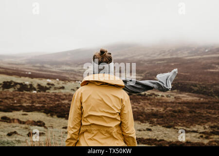 Großbritannien, Schottland, Isle of Skye, Rückansicht der jungen Frau in ländlichen Landschaft Stockfoto