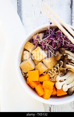 Miso Ramen Suppe mit Nudeln, hokaido Kürbis, rote Radieschen Sprossen, gebratenem Tofu, Shimeji Pilz und König Trompete Pilz Stockfoto