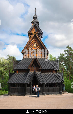 Norwegen, Blick im Sommer auf Touristen, die eine traditionelle norwegische Stabkirche im Norsk Folkemuseum im Bygdøy-Gebiet von Oslo, Norwegen, betreten. Stockfoto