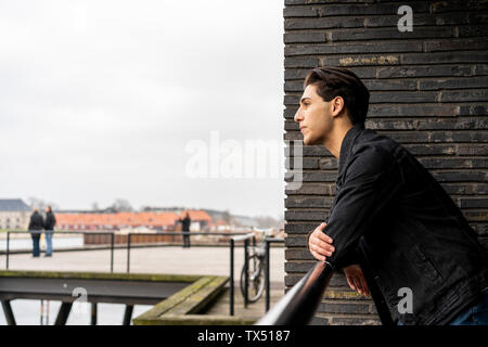 Dänemark, Kopenhagen, junger Mann am Geländer an der Waterfront schiefen Stockfoto