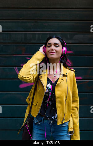 Porträt der jungen Frau mit weiße Kopfhörer, tragende schwarze Lederjacke Stockfoto