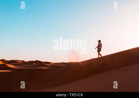 Sultanat Oman Wahiba Sands, Mitte der erwachsenen Mann spielt mit Sand in der Wüste Stockfoto