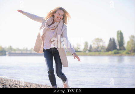 Sorglos reife Frau am Flußufer Stockfoto