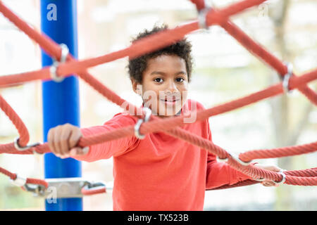 Little Boy spielen auf dem Spielplatz im Park, klettern in einem Jungle Gym Stockfoto