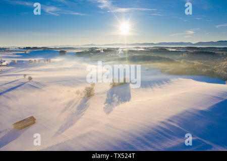 Deutschland, Bayern, in der Nähe von muensing Winterlandschaft mit Alpen bei Sonnenaufgang, Luftaufnahme Stockfoto