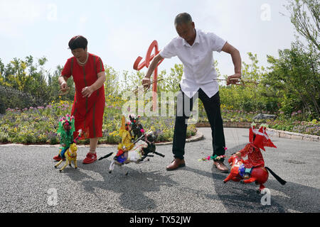 (190624) - ZHENGZHOU, Juni 24, 2019 (Xinhua) - Leute führen Puppenspiel in Henan Garten während der Peking Internationale Gartenbauausstellung im Landkreis Yanqing, Peking, Hauptstadt von China, 23. Juni 2019. Im zentralen Teil von China, Henan liegt in der Mitte - geringere Reichweite des Gelben Flusses, der längste Fluss des Landes. Neben seinem reichen historischen und kulturellen Ressourcen sowie natürliche Landschaften, Henan, als wichtigste landwirtschaftliche Provinz, ist auch als wichtigsten produzierenden Bereich der landwirtschaftlichen Produkte in China angesehen. Die Ideen der "klaren Gewässern und Berg, inmitten von üppiger Vegetation. Stockfoto