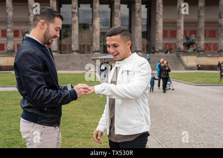 Junger Mann auf Ring zu seinem glücklichen Freund am Lustgarten, Berlin, Deutschland Stockfoto