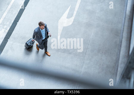 Blick von oben auf die Geschäftsmann wandern mit Gepäck und Kaffee zum Mitnehmen Stockfoto