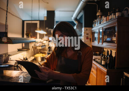 Junge Frau im Restaurant Küche in Buch schreiben Stockfoto