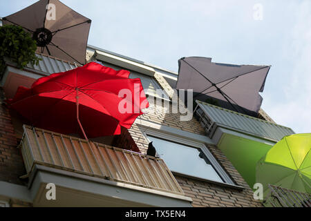 Köln, Deutschland. 24. Juni, 2019. Bunte Sonnenschirme stehen auf den Balkonen eines Hauses. Credit: Oliver Berg/dpa/Alamy leben Nachrichten Stockfoto