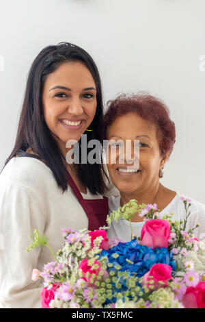 Lächelnde Mutter und Tochter mit Ihren Blumenstrauß Stockfoto
