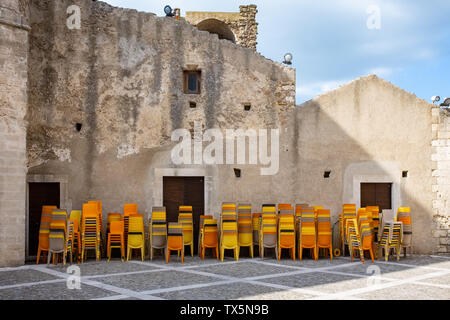 Miglionico schloss mit orange farbenen Haufen Stühle. Region Basilicata, Italien Stockfoto