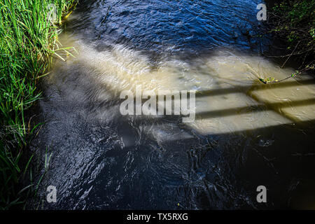 Eine Brücke im Wasser spiegelt - die Windrush Fluss in den Cotswolds UK Stockfoto