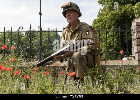 US Airborne Soldat (Re-Enactor) von Mohnblumen, Barnard Castle, 1940 Wochenende, 2019, Teesdale, County Durham, UK umgeben. Stockfoto