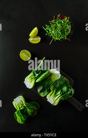 Bok Choi, Kalk Keile, Grün sprießt auf schwarzem Hintergrund, Ansicht von oben Stockfoto