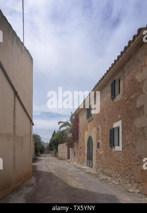 SES SALINES, MALLORCA, SPANIEN - 15 April, 2019: Alte authentische leer Kies Straße im Zentrum der Stadt an einem bewölkten Tag am Anfang der Saison Stockfoto