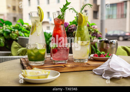 Sommer alkoholfreie Getränke, eine Reihe von limonaden. Limonaden in Krügen auf dem Tisch, die Zutaten, aus dem sie bestehen, sind um angeordnet. Stockfoto