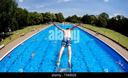 Hannover, Deutschland. 24. Juni, 2019. Ein junger Mann springt in die Sonne in einen Pool, in den Hotels Kleefelder schlecht. (Geschossen mit Fischaugenobjektiv) Credit: Hauke-Christian Dittrich/dpa/Alamy leben Nachrichten Stockfoto