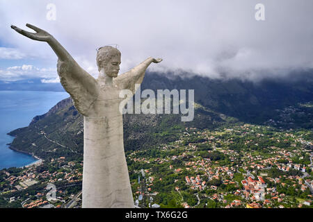 Unglaublich große Denkmal von Jesus mit ausgestreckten Händen auf dem Meer Hintergrund in Maratea Hill - Stadt an der Tyrrhenischen Küste in Italien. Antenne horizontal Stockfoto