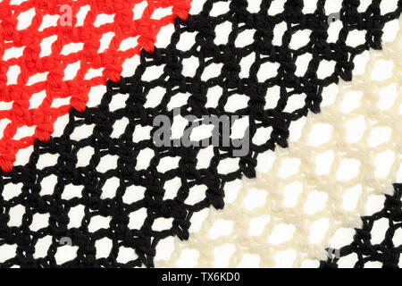 Schwarz, Rot und leight beige Gestrick. Öse/lace Netz heften. Strickmuster makro Textur Hintergrund Stockfoto