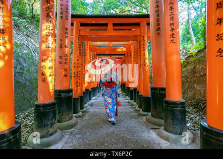 Asiatische Frauen in der traditionellen japanischen Kimonos an Fushimi Inari Schrein in Kyoto, Japan. Stockfoto