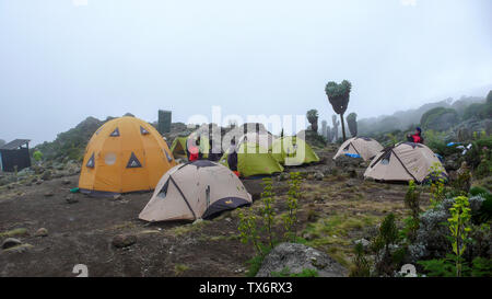 Mount Kilimanjaro/Tansania: 4. Januar 2016: Hochlager auf dem Mount Kilimanjaro mit vielen Menschen Vorbereitung und Einrichtung der Lager Stockfoto